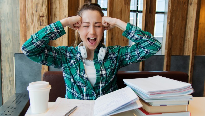Eine Schülerin lernt für das Abi und die Vorbereitung strengt sie an.